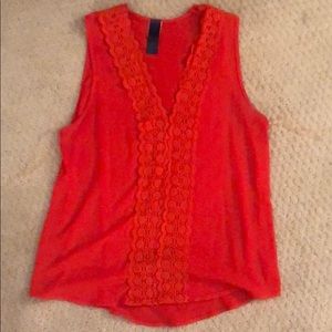Red sleeveless blouse with lace detailing.
